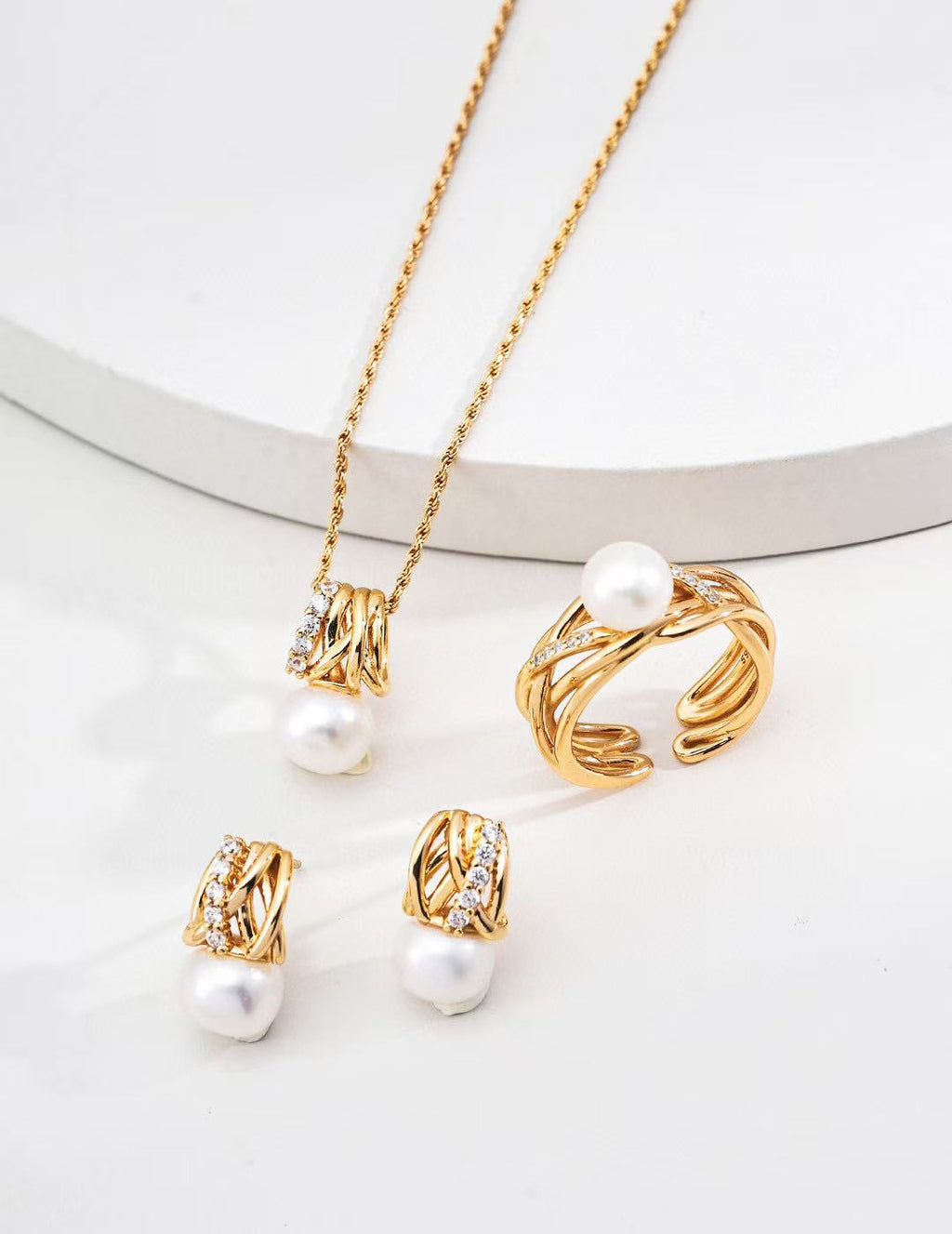 Gold jewelry set with pearls on a white background