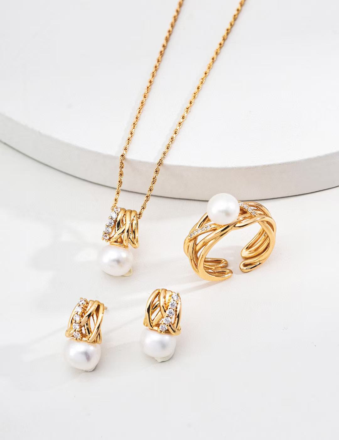 Gold jewelry set with pearls on a white background